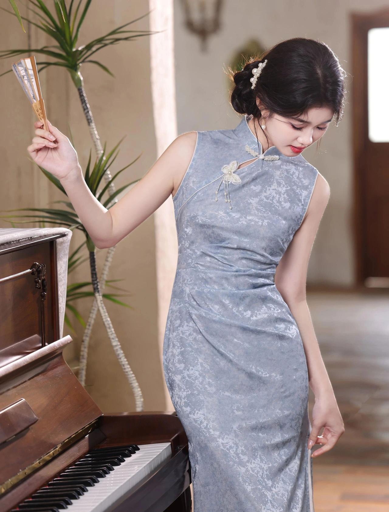 旗袍剪裁修身，勾勒出曼妙身姿，领口精致的盘扣与流苏吊坠，增添了几分灵动雅致。乌黑