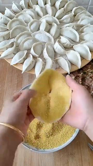 最后一个饺子了，包一个不一样的。蘸点小米，然后把底下这个一搅，搅个窟窿。蘸点小米