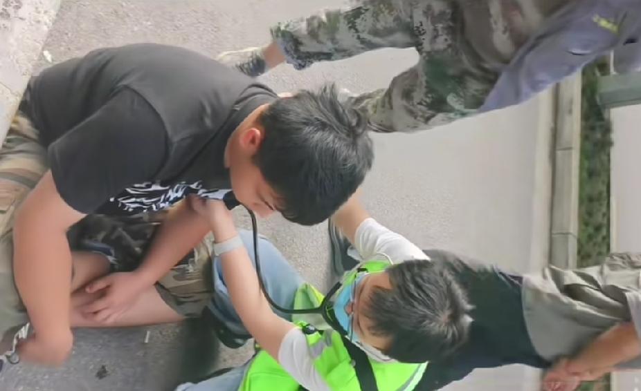 一名小伙子昏倒在地上，陌生男子好心将小伙子救醒，120急救人员来后，陌生男子做出