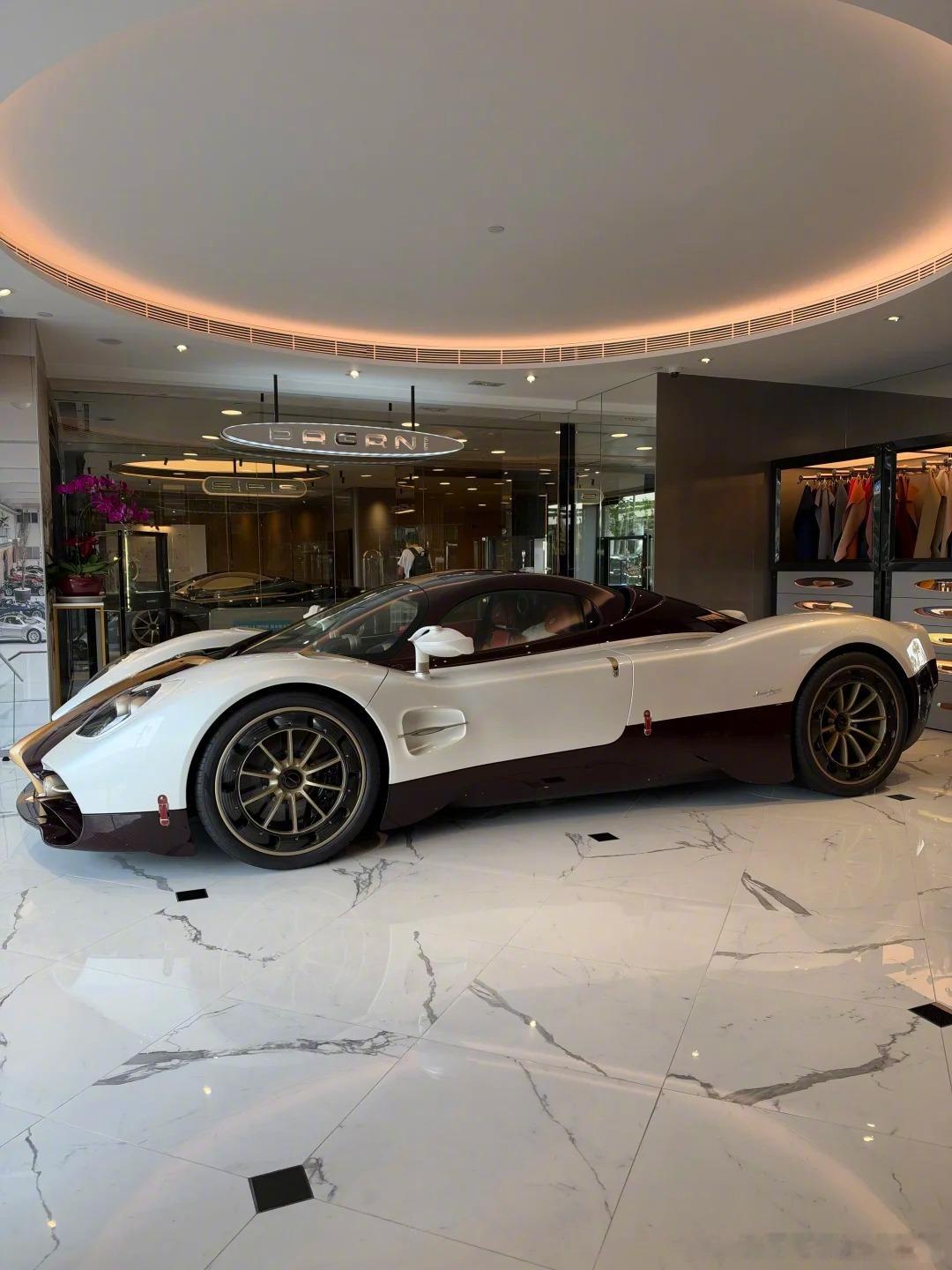 一台颜色接近于意大利白的Pagani Utopia，红色裸露的碳纤维+金色拉花高