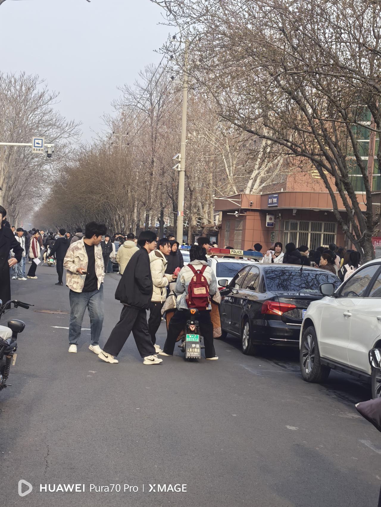 今天是星期六，早晨送外孙去学英语，路过一学校，看到门口两侧的人行道上都是候考的考