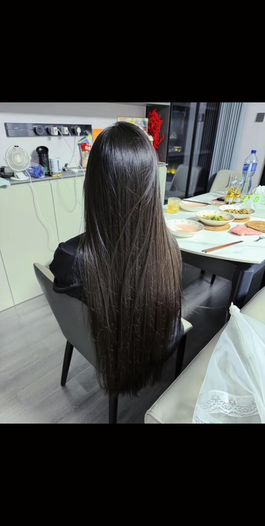 长发妹子坐在餐桌旁，准备开饭。