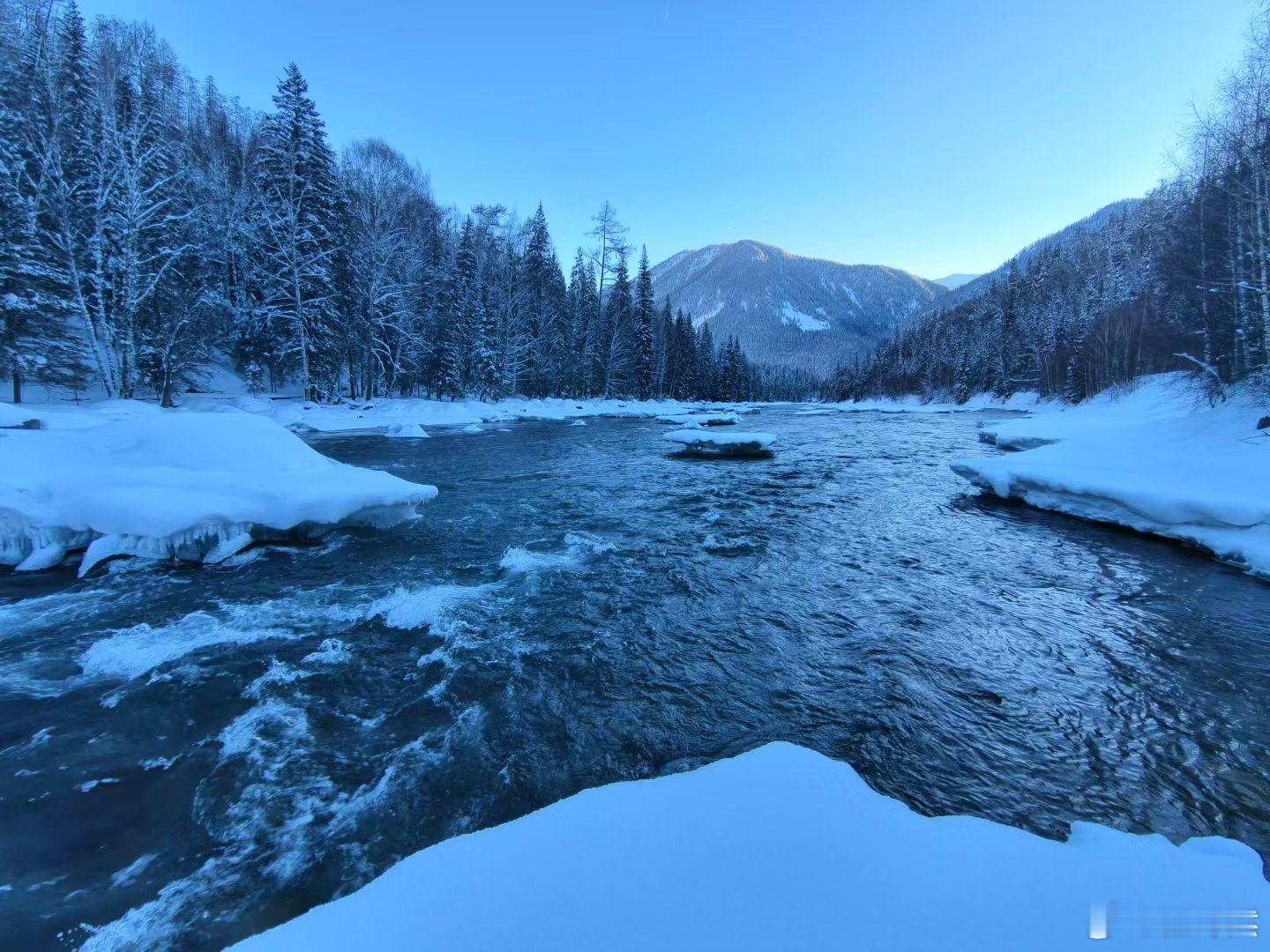 冬日的喀纳斯湖景，湖面之上的晨雾袅袅升腾，轻柔地弥漫开来，将四周的一切都温柔地笼