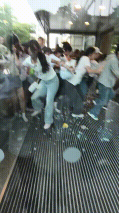 现场场面完全失控，大批人群疯狂往前猛冲，门口玻璃直接被挤碎裂，锋利碎玻璃划伤不少