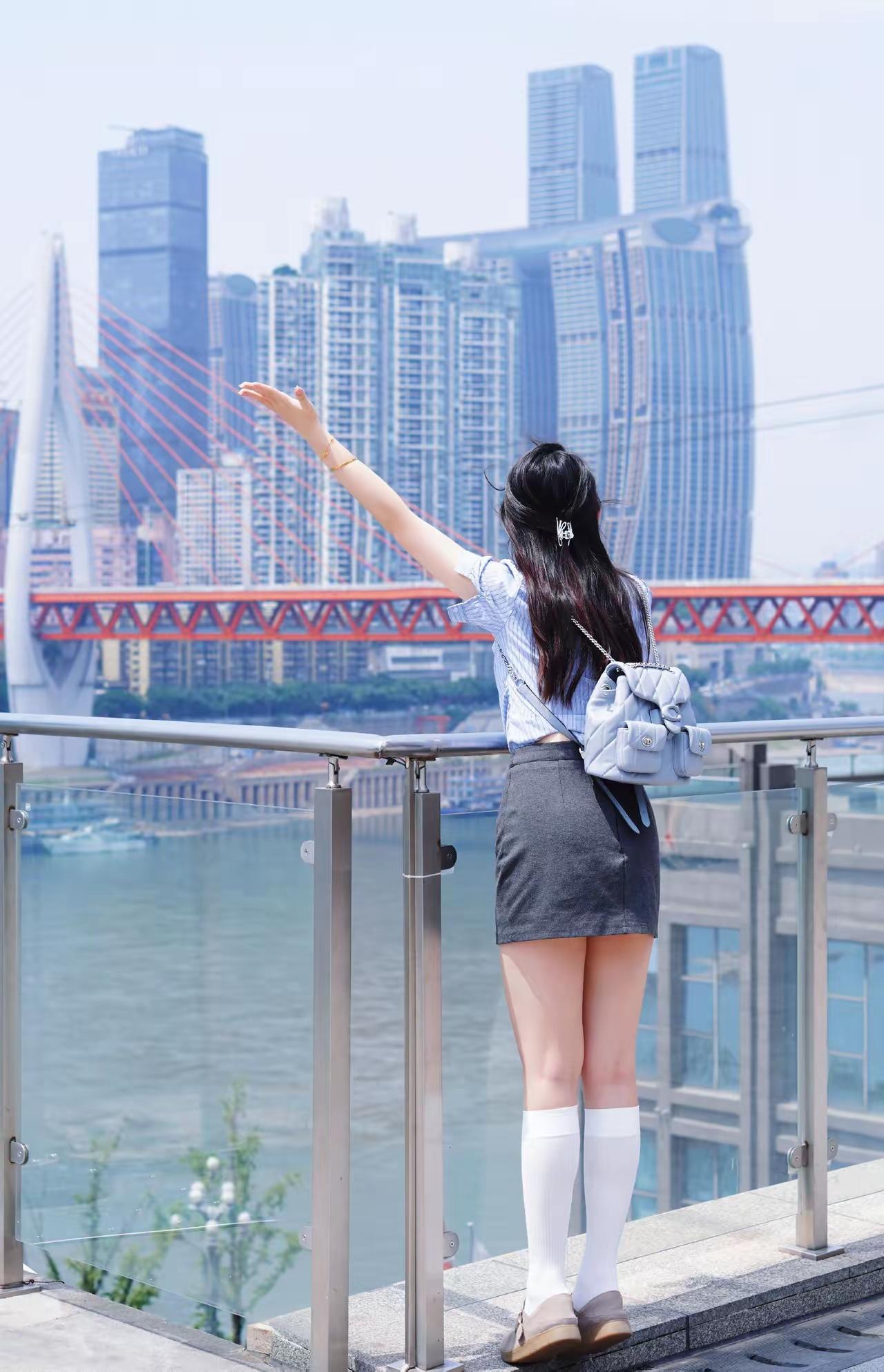 城市天际线下的少女，背对镜头，眺望远方，感受都市的繁华与宁静。