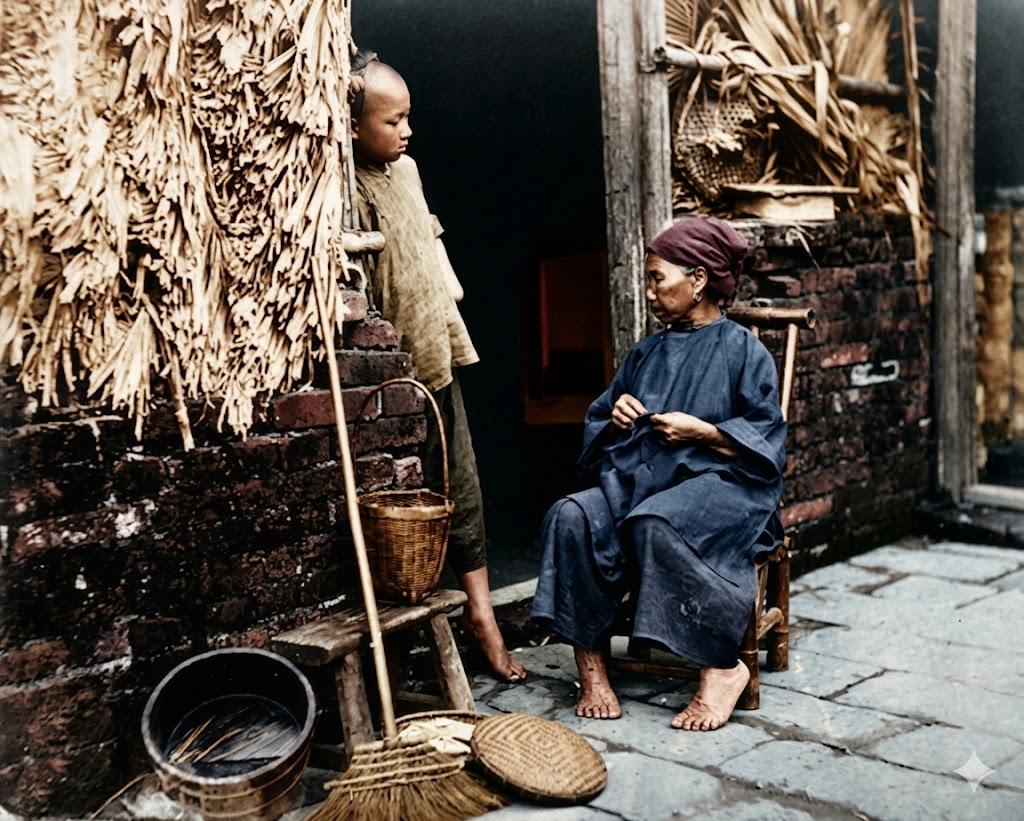 清末民初，南方一户普通人家的门廊前，端坐的老妇身着传统大襟布衫，头裹头巾，赤脚坐