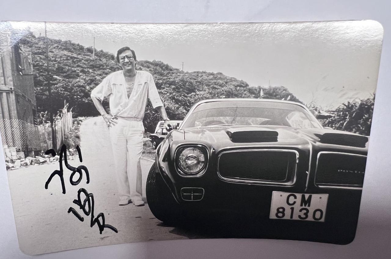 一张谢贤年轻时的照片，“四哥”站在一辆黑色轿车旁边，脸上露出开心的笑容。

那时