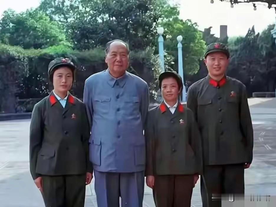 这张彩色老照片里，毛主席立于中央，身旁四位身着65式军装的工作人员伴其合影，庭院