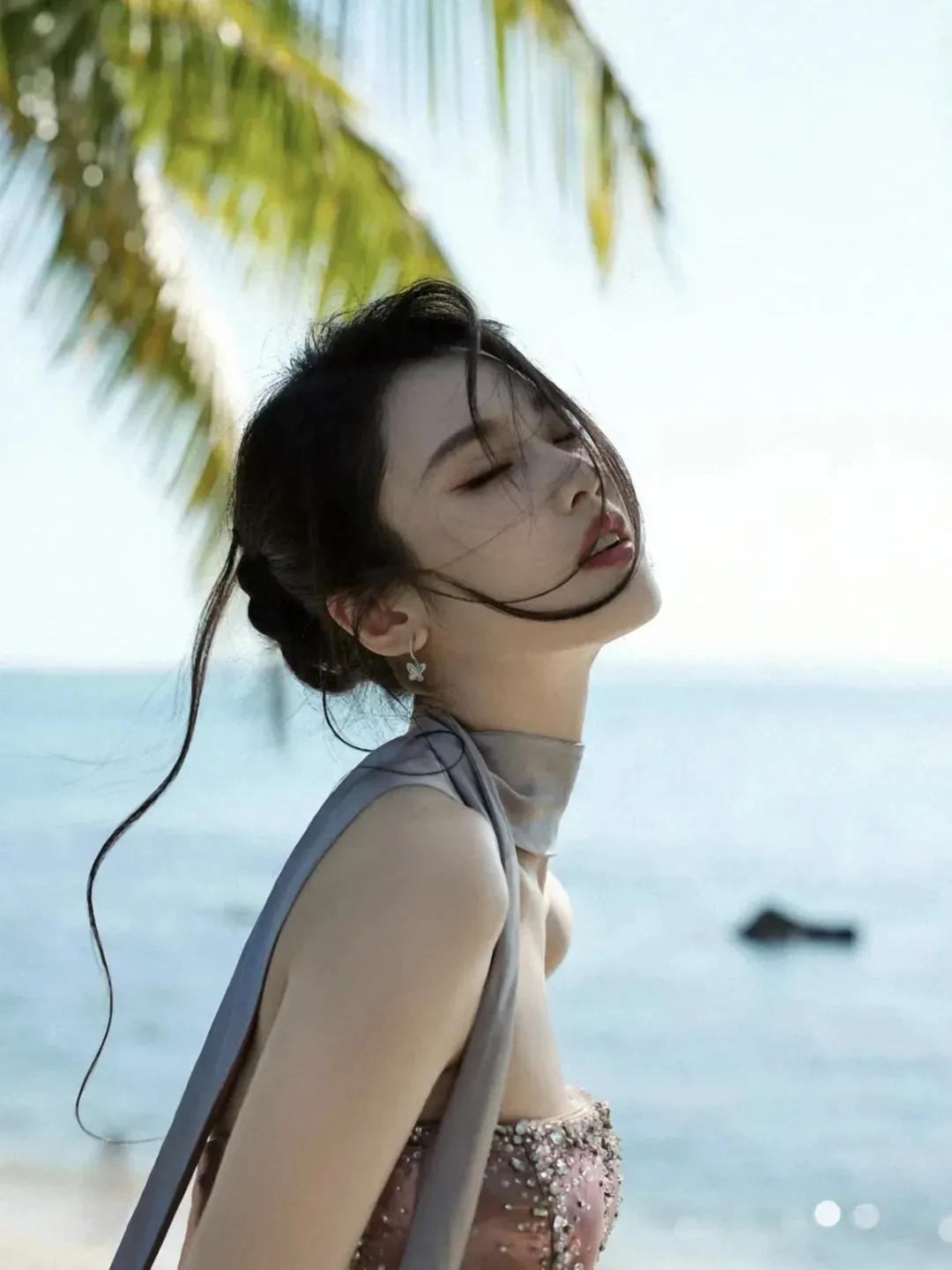 张慧雯海边微风拂面，少女轻闭双眼，享受宁静时光。