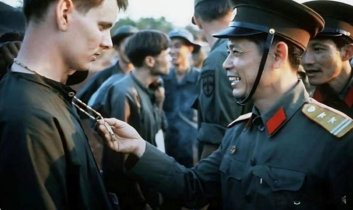 1973年2月，越南战争期间美军战俘遣返时，一名北越军官查看美军战俘脖子上佩戴的
