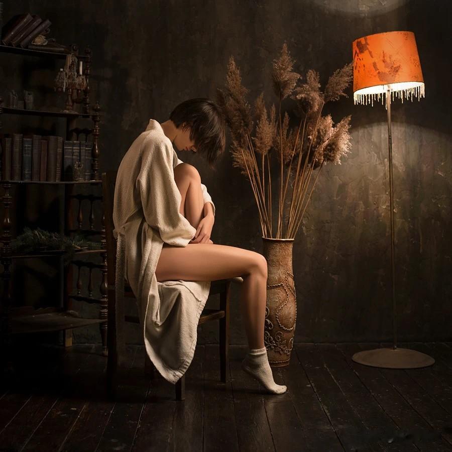 主体与背景明暗层次分明，视线焦点落在人物状态上，那盏灯让背景不显沉闷，也凸显平和