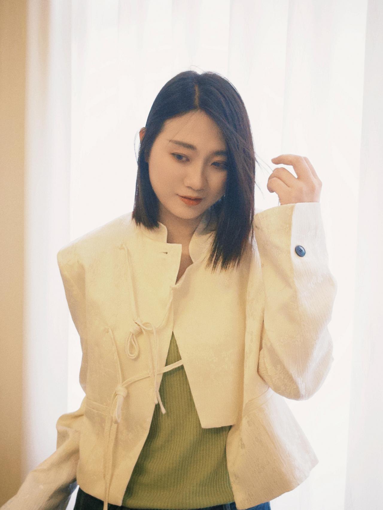 这姑娘穿着浅黄色外套，有点酷。