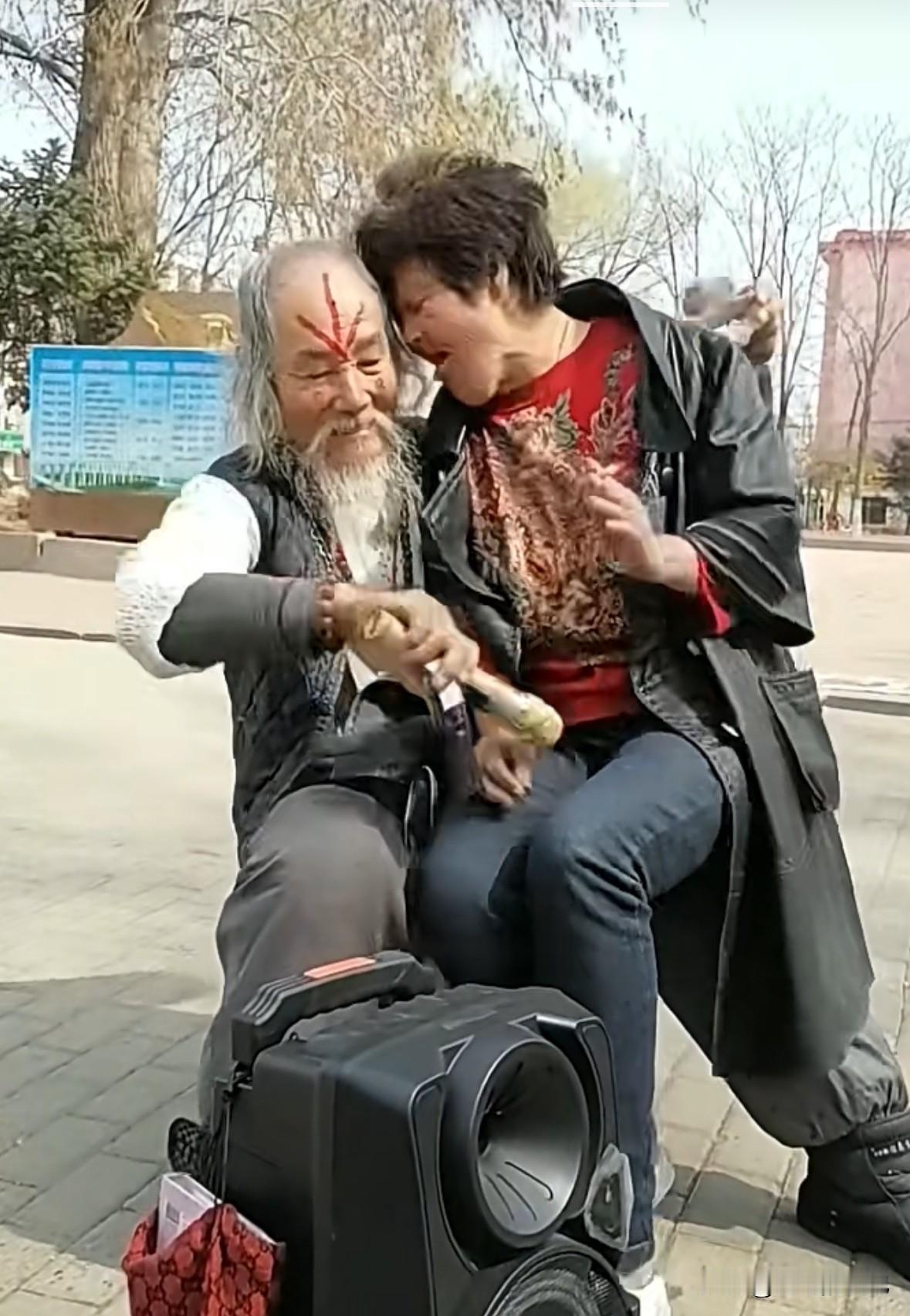 老头坐在椅子上，老太太被他抱在怀里，老头突然把麦克风对准了女人那个部位（图一），