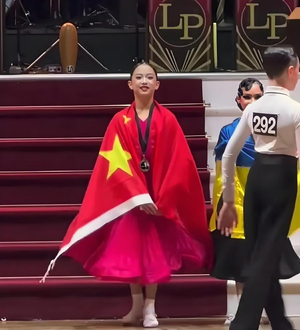 "11岁的小花身披五星红旗闪耀国际舞台，自信鞠躬的瞬间让全网破防！她完美继承邓超