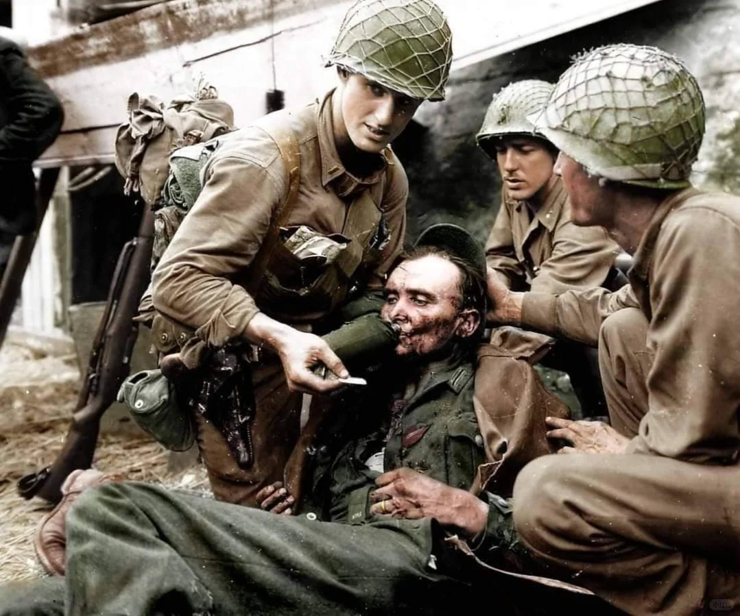 1944年，在法国诺曼底战役期间，几名美国士兵正在救助一名受伤的德国士...