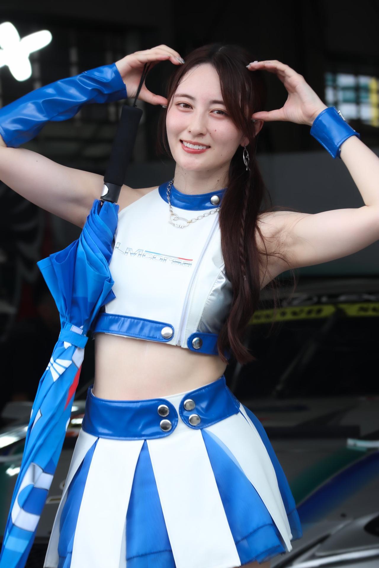 蓝衣美人笑，雨伞映晴空。