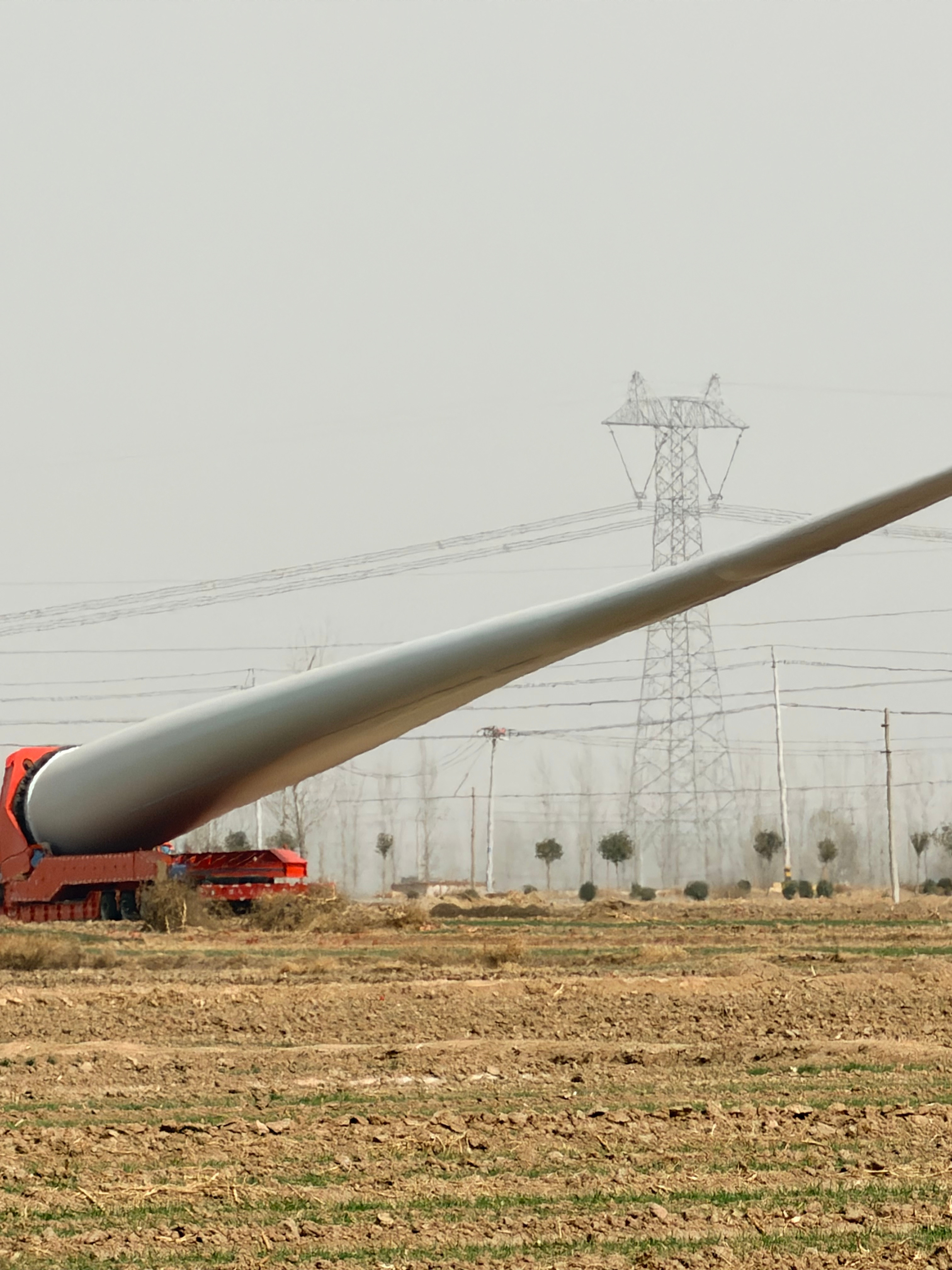 路窄了真不行啊！像这种风力发电的风扇叶，因为路上过不去，只能先临时放在这了“要想