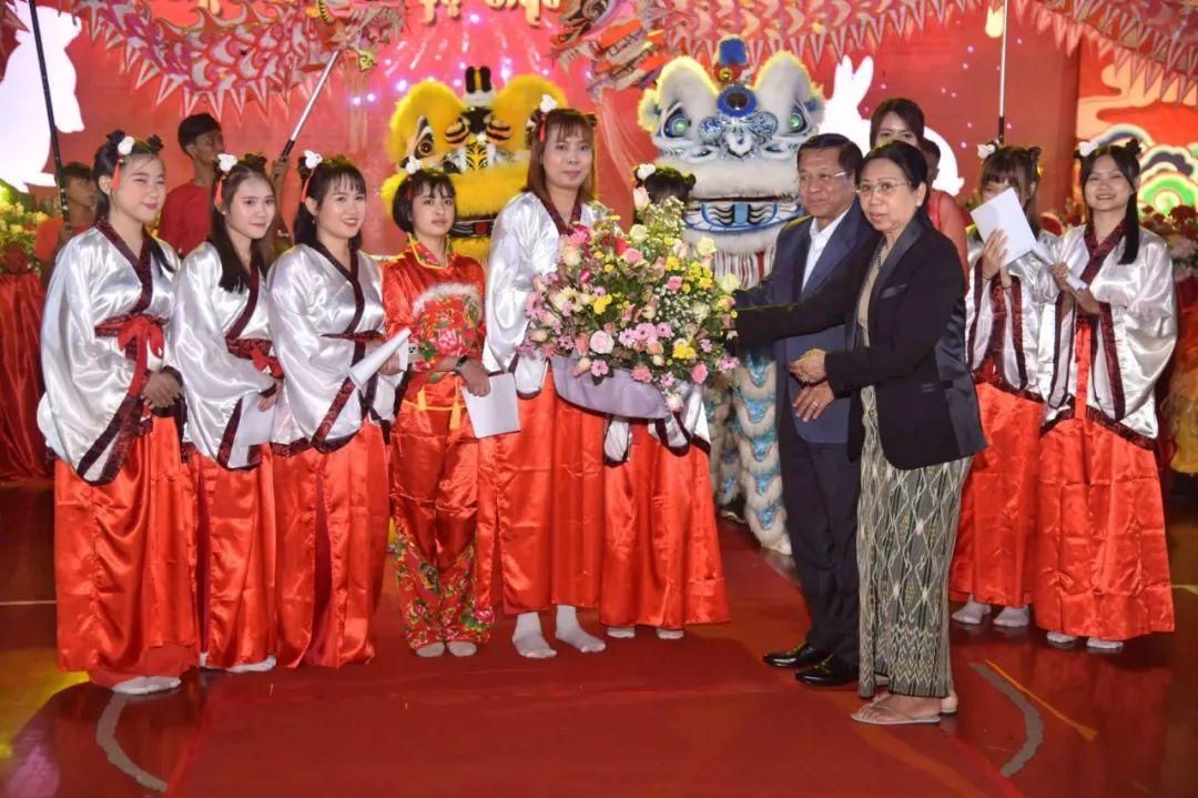 敏昂莱夫妇站在舞台上，他们夫妻身上的黑衣衬得舞台红更加的喜庆。看来敏昂莱夫人喜欢