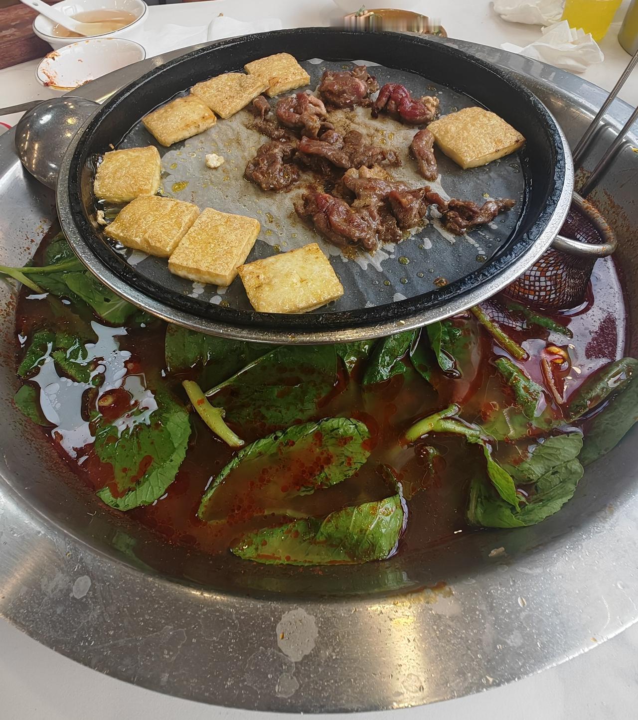 贵州的美食太合我们的胃口了，酸汤牛肉火锅上面还有一个小锅，可以烤洋芋、豆腐、牛肉