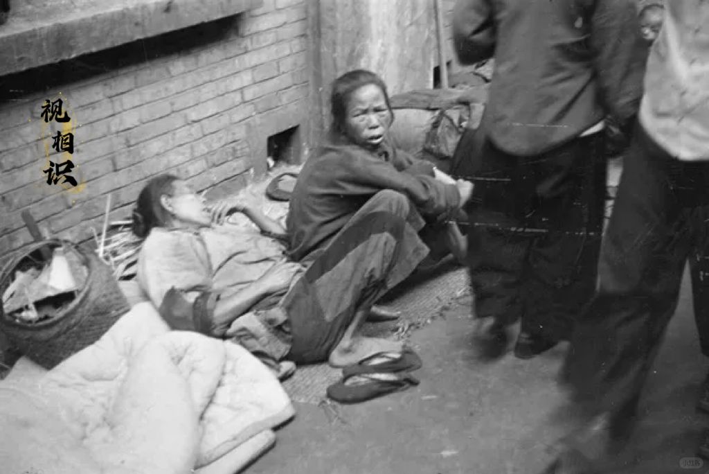 1937年，上海，几名难民躺坐在房檐下的场景，镜头中可以看到他们的眼神中充满深深...