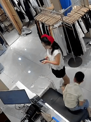 小男孩突然一把将服装店里的一位小姐姐抱起来，导致小姐姐重心不稳重重的摔倒在地上！