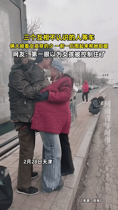 俩大娘一前一后，用衣服把一位女孩紧紧包裹住，女孩顿时动弹不得，猛一看还以为出啥事