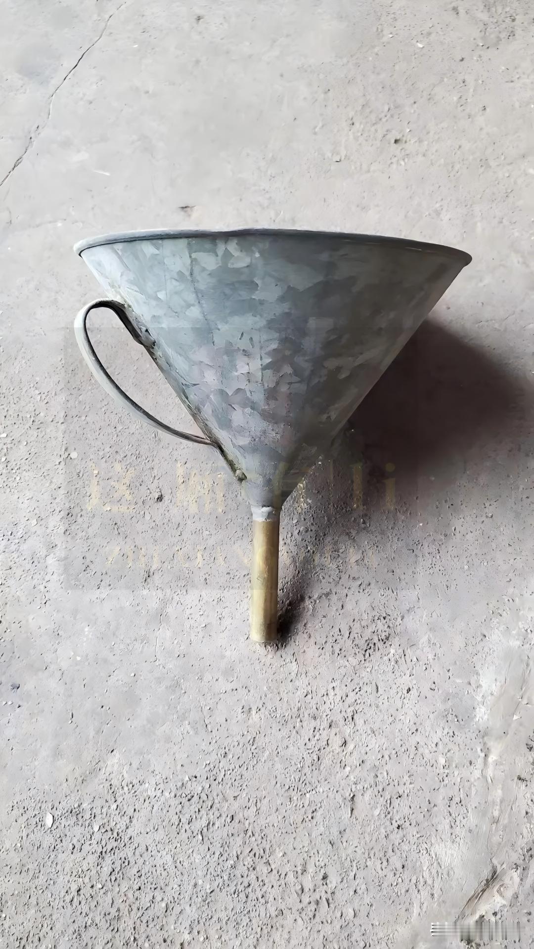 还有具有时代印记的物件吗?
中空锥形，留着长长的“尾巴”。用铁皮做成，有弯把手方