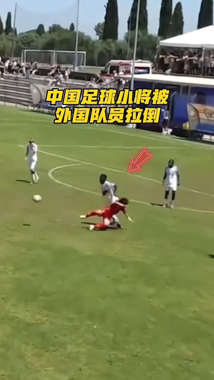 中国足球小将被外国队员拉倒，一旁的队友跟裁判示意这是脏动作，没想到过去要球还被推