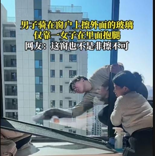 这窗户是非擦不可吗？太危险了！

一男子骑在窗户上擦外面的玻璃，半个多身子在外面