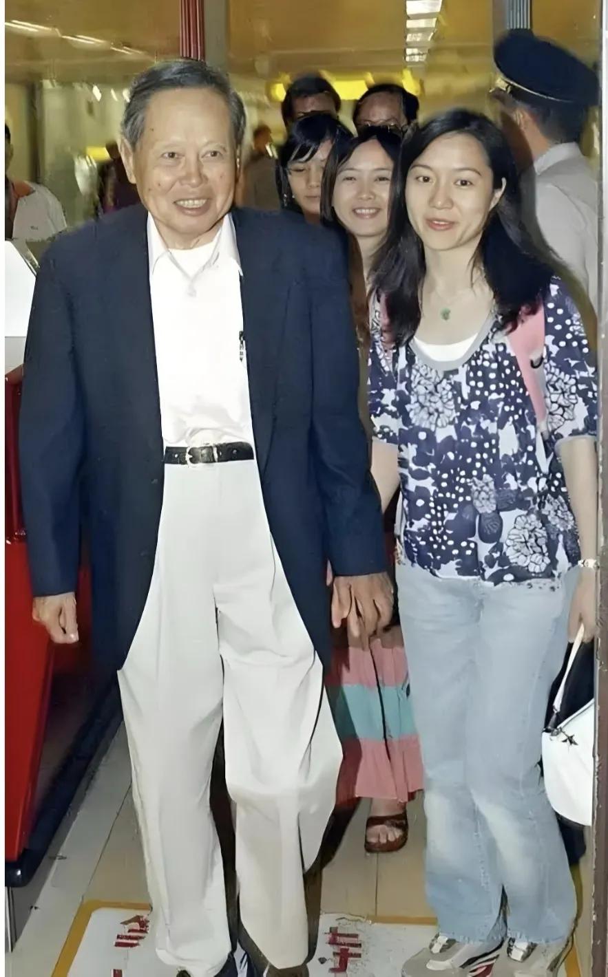 这张翁帆与杨振宁教授的牵手照片，杨老多精神：他身着白色衬衣，白色裤子，腰带非常醒
