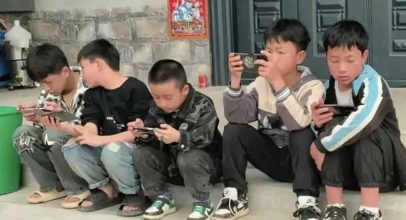 从小玩游戏长大会聪明吗？
这几个小孩每天放学就是这样在庄头聚一块在手机上打游戏，
