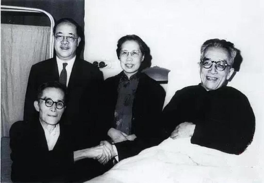 1961年，病重的梅贻琦看望因心脏病而住院的胡适，二人坐在病床边握手的一张合影，