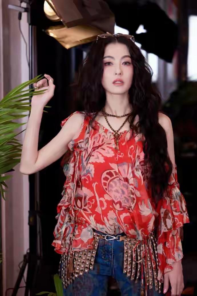 张柏芝身穿上衣的设计很抢眼，底色是很亮眼的暖橘调，上面印着浅色系的复古花纹，有点