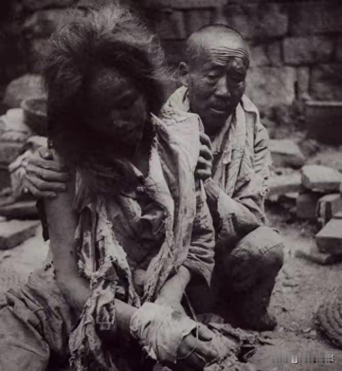 照片中这个可怜的女子，双手好像是被捆绑住了，身上的衣服也是破破烂烂，几乎全是一些