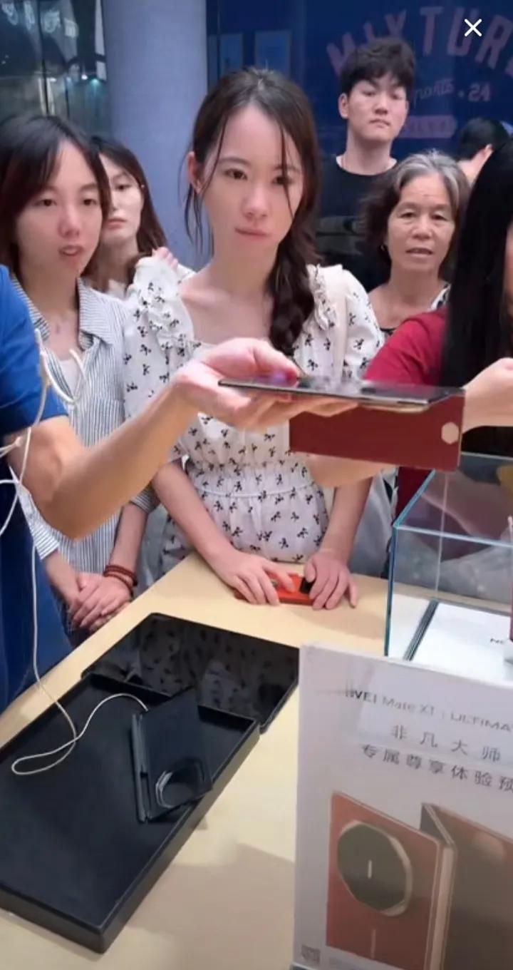 已经是9月21日晚上9点50了，然而，深圳华为旗舰店里依然挤满了顾客。这些顾客都