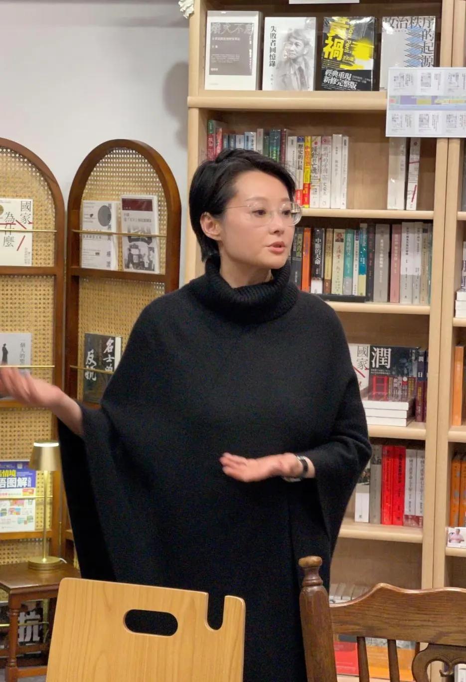 袁立现身日本一家书店学习参观，她站在室内，双手抬起，手掌张开，和每一个人认真交流