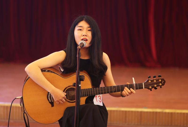 流浪女生，街头卖唱，歌声飘荡在寒风中，她那略带沙哑的声音如一束微光，穿透了人们的