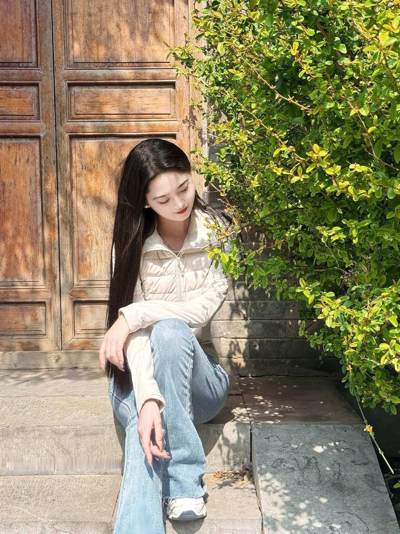 阳光下的静谧时光，沉思的少女与绿植相伴。