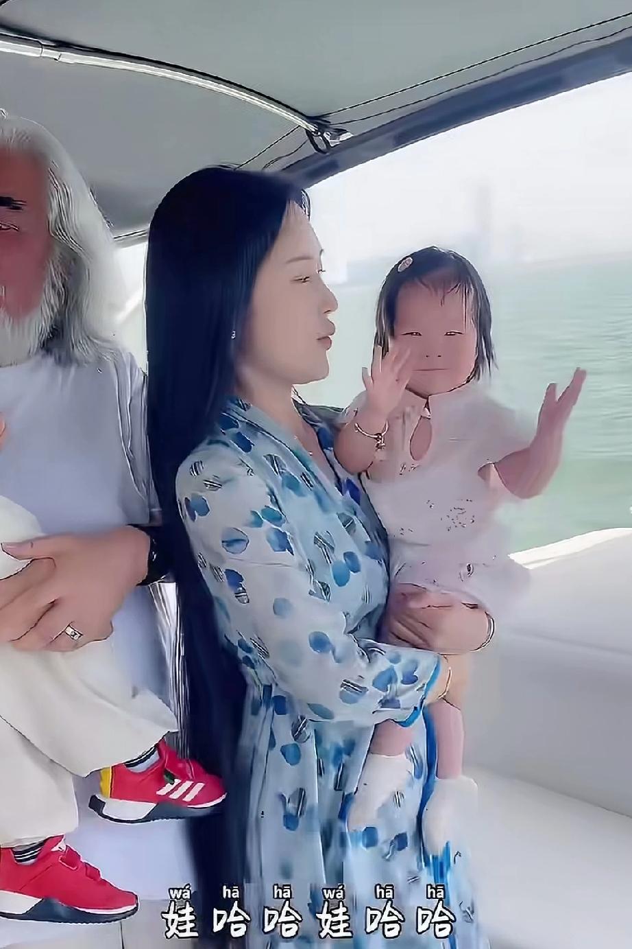 张纪中与小娇妻怀抱着一儿一女，画面温馨和谐，满是幸福之感。张纪中已是满头白发，而