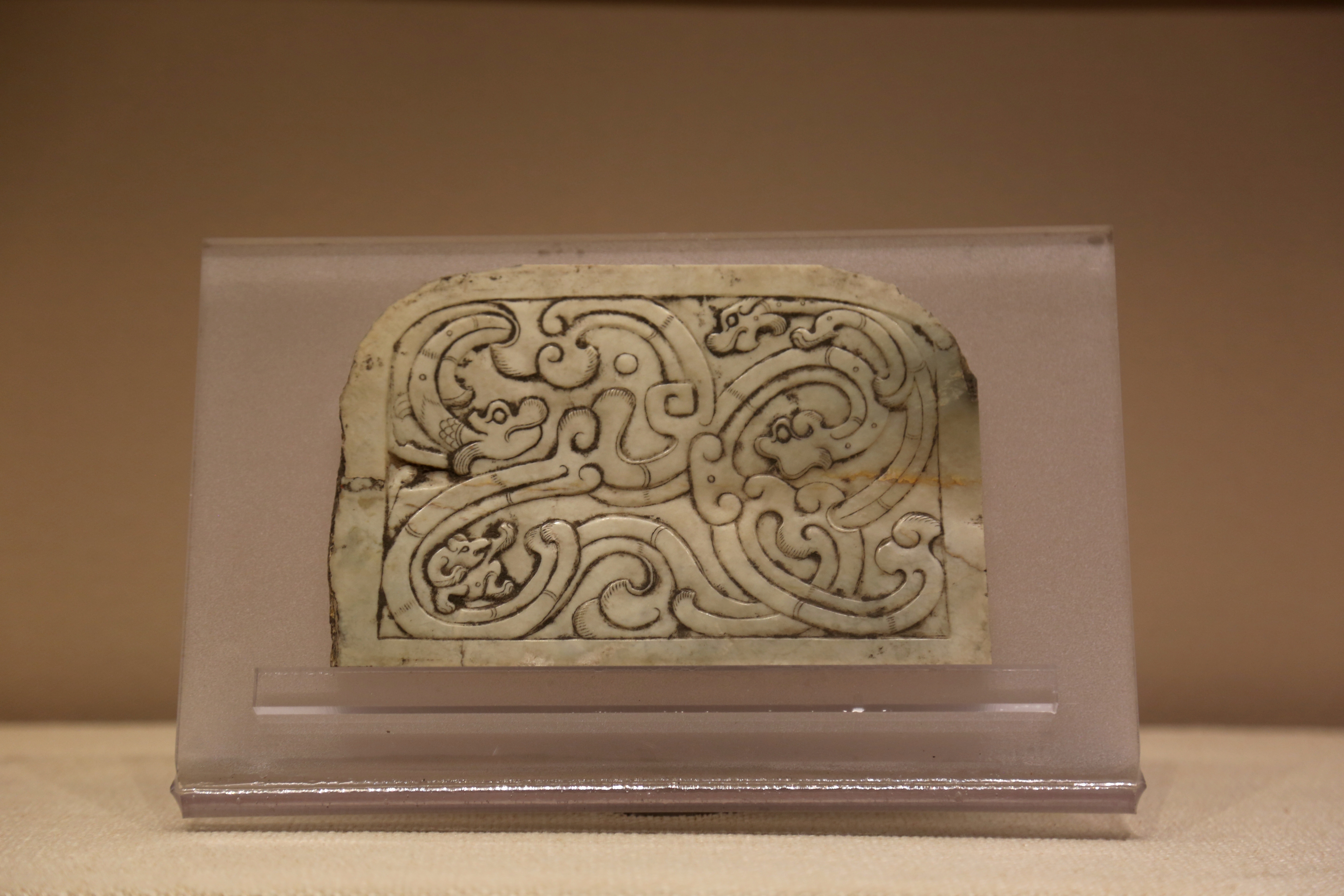 河南开封杞县文管所藏汉代 三螭龙纹玉牌饰. 左下角还有一只“比武”的熊 