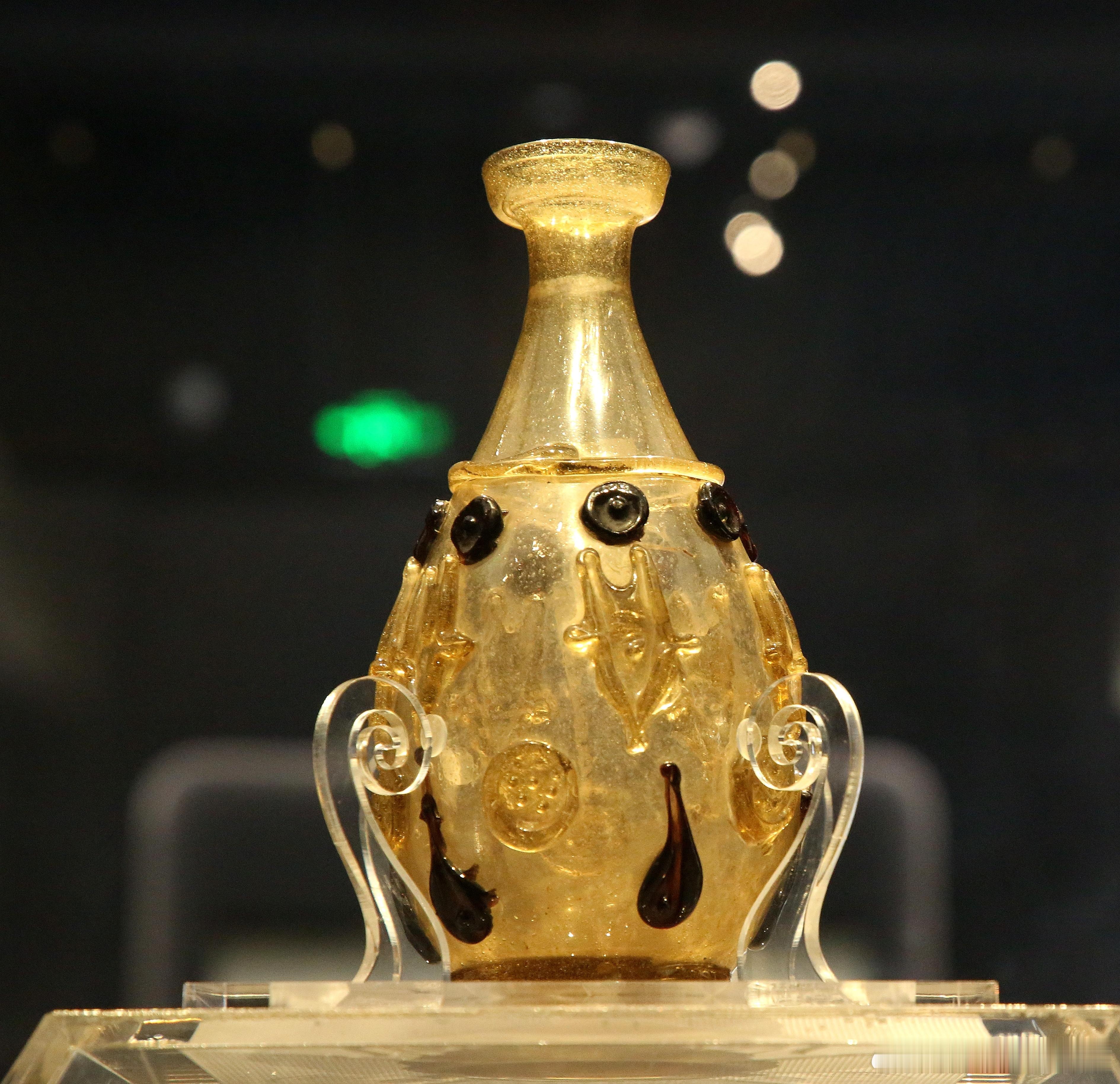 盘口细颈淡黄色琉璃瓶·唐法门寺博物馆藏1987年法门寺地宫出土。高 21 厘米，