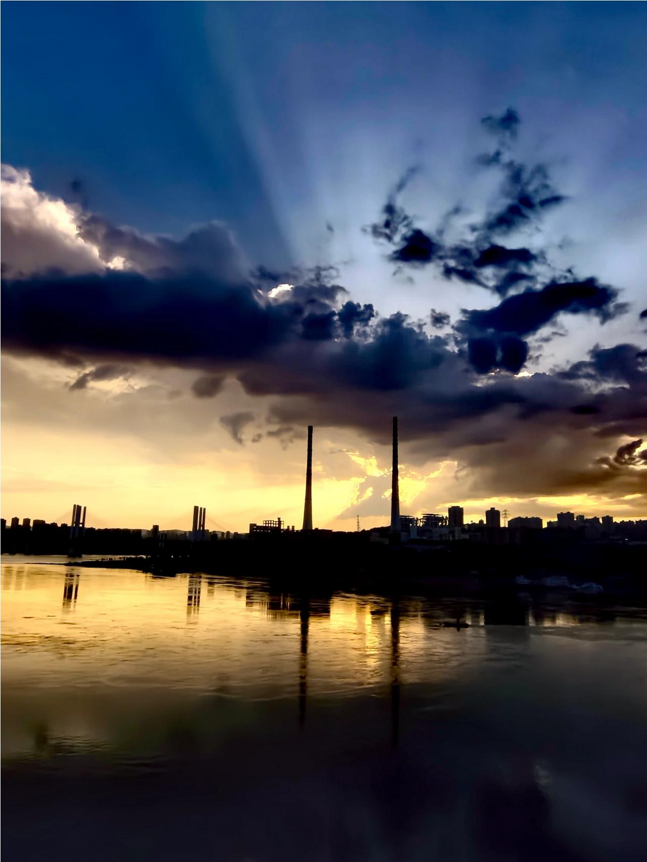 7月26日，夕阳西下的时候天空出现丁达尔光，李家沱大桥和黄桷坪电厂大烟囱同框，美