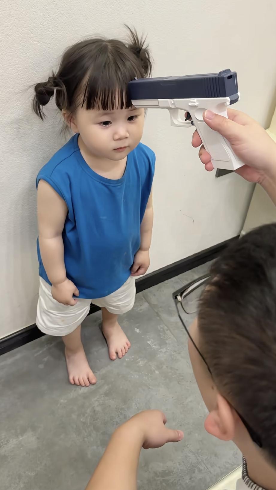 男子拿着一把玩具手枪抵在了女儿的脑门上，威胁着她说叫爸爸[泪奔]

女儿很乖，连