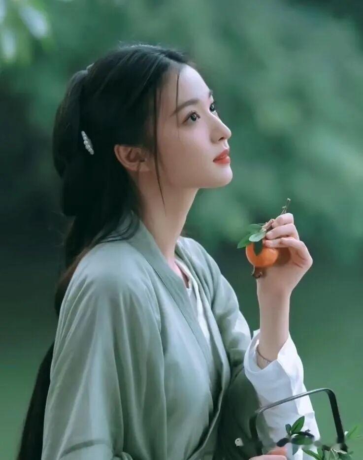 绿裙美人倚芳树，轻嗅桃香意自闲。