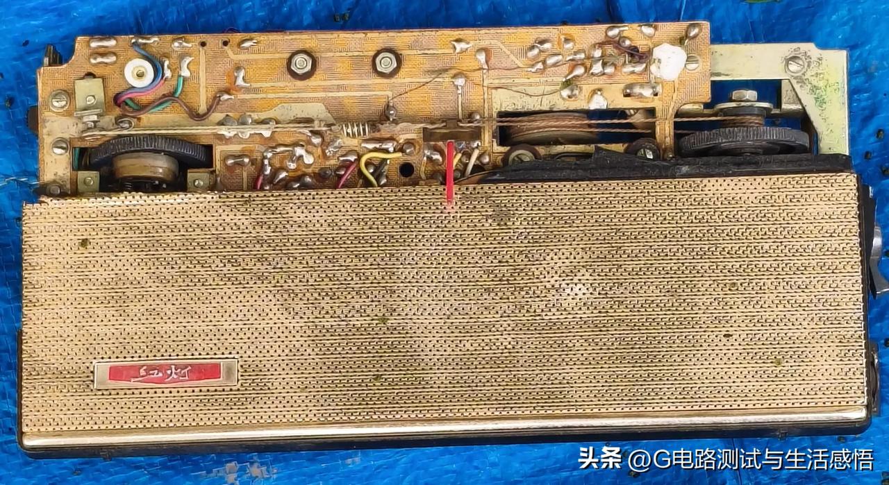 于旧货市场地摊，拍到一台残缺的红灯晶体管收音机，前调谐盘已丢失。
查看内部，老式