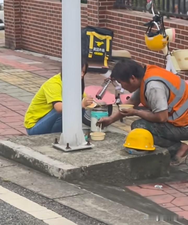 你看这对小夫妻，爱情哪有那么多条件
两个年轻人穿着工装，蹲在马路上，面前摆着从家