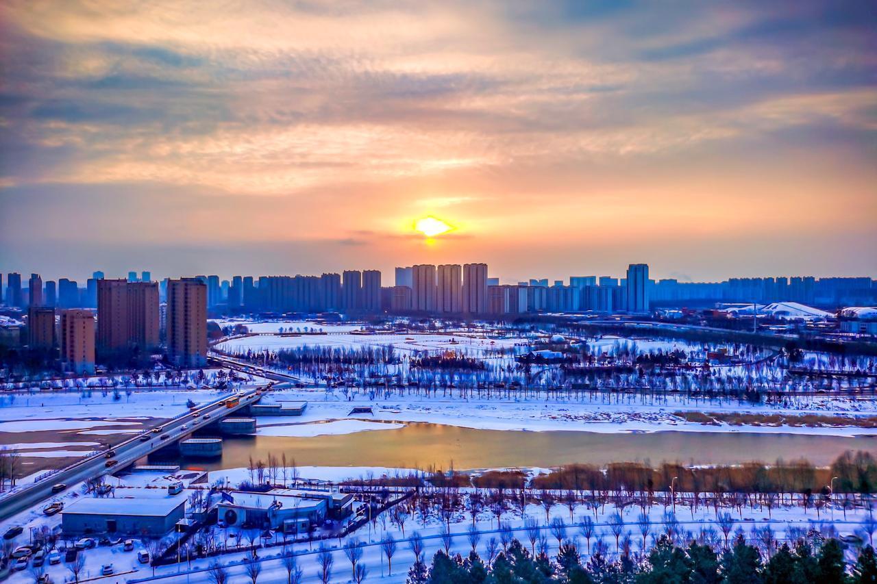 苏醒
 
数九的寒气，像凝固的棉絮，裹着整座城仍沉眠在夜的余温里，伊通河却已在晨