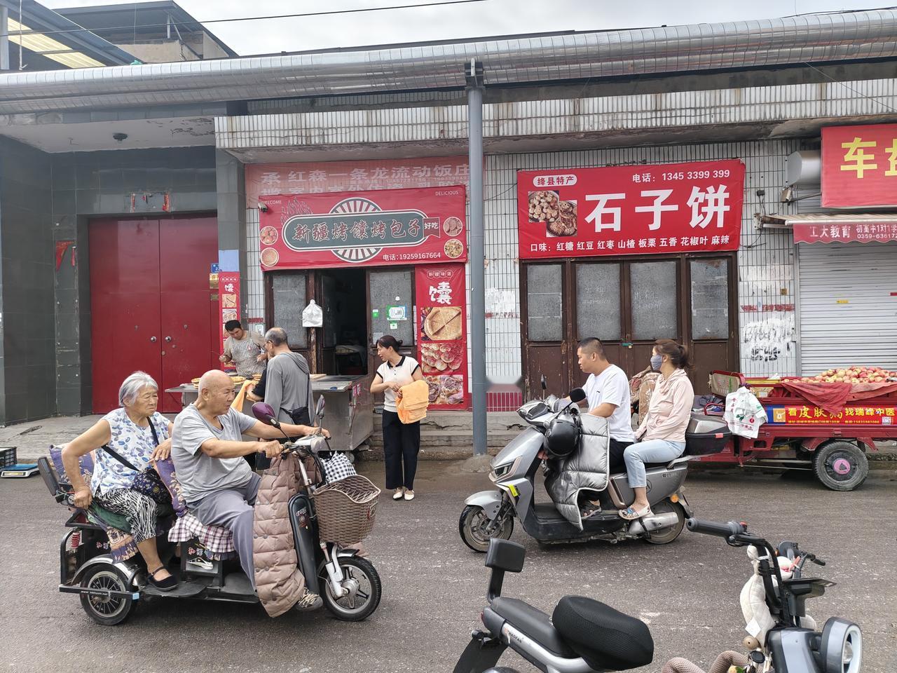 瞧瞧，在运城盐湖西街早市，一个女人在免费发放毛巾，她让领了毛巾的人到对面，一位男
