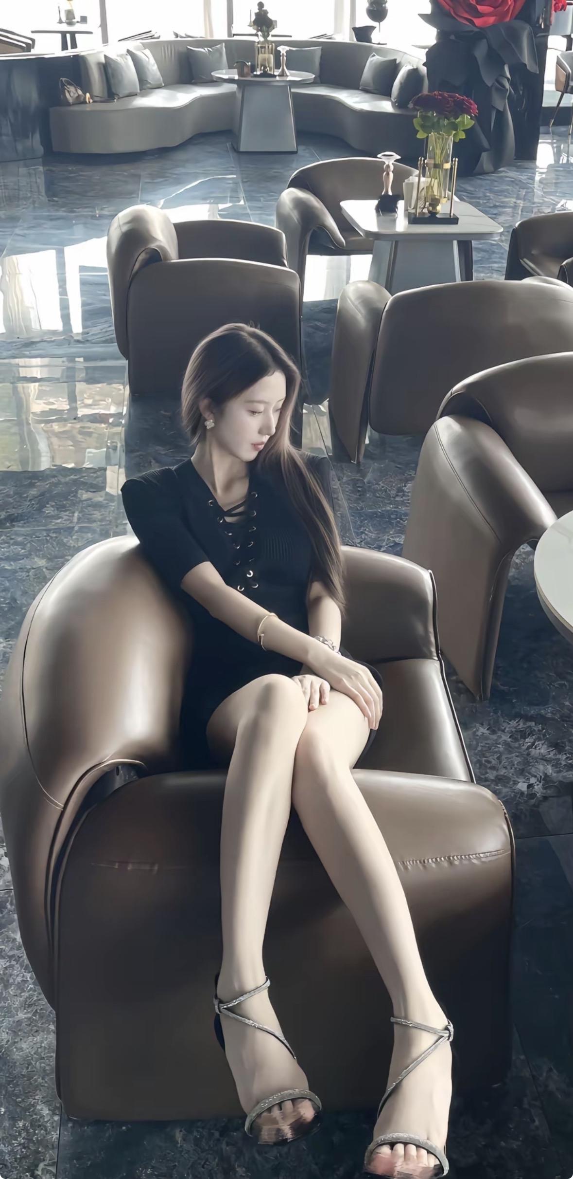 • 服装：身着一袭黑色短袖连衣裙，胸前独特的镂空系带设计，打破了纯黑的沉闷，增添