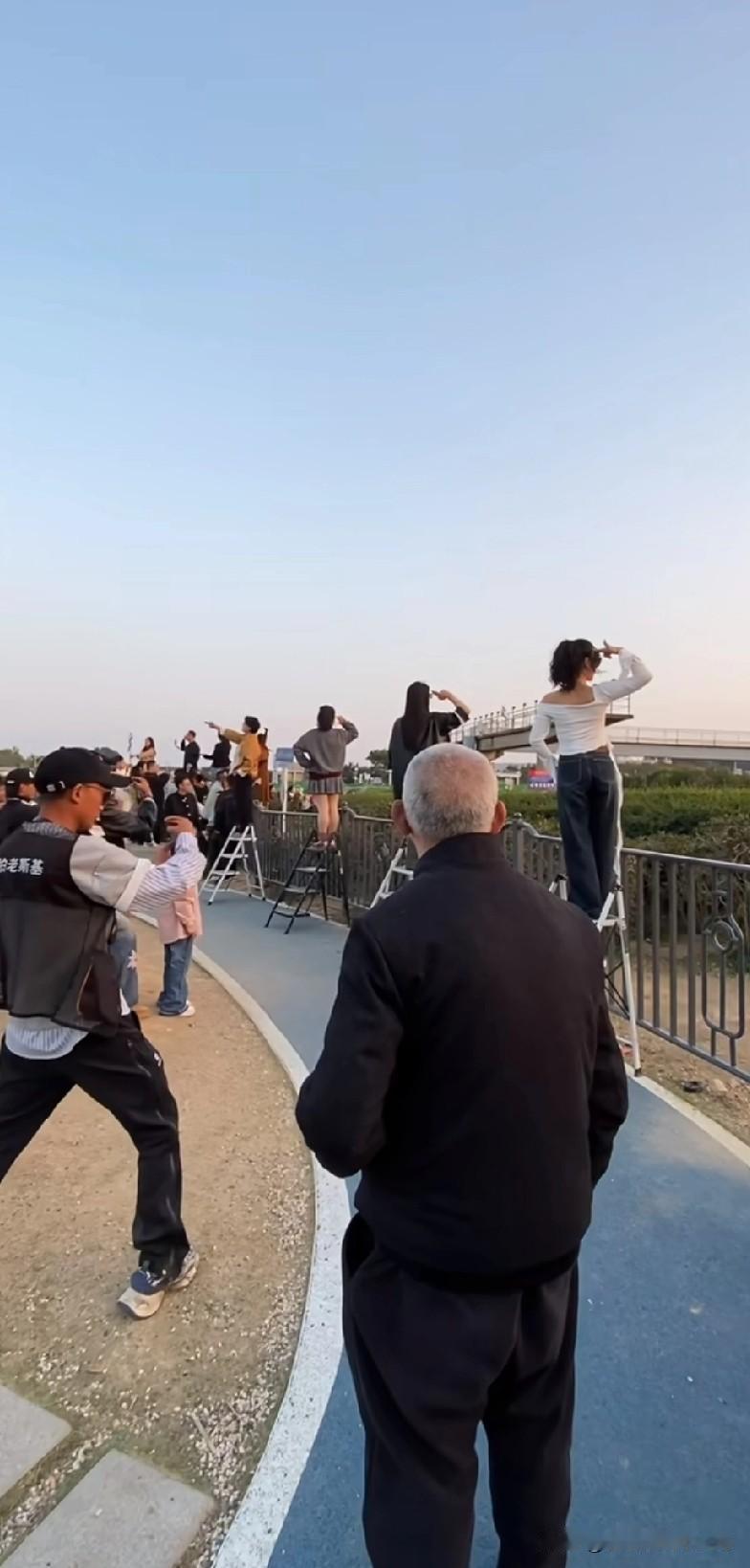 哈哈，刚刷到网红拍照现场，我简直笑疯啦！一群小姐姐整齐地转身、甩头发，表情管理瞬